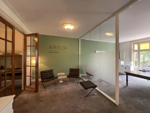 Wachtruimte van advocatenkantoor Arbor aan de Oranje Nassaulaan met moderne stoelen en glazen scheidingswand.